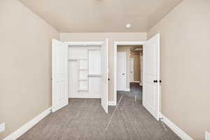 Unfurnished bedroom with a closet and carpet flooring