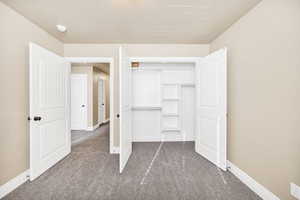 Unfurnished bedroom with carpet and a closet