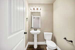 Bathroom with baseboards and dark wood-style floors