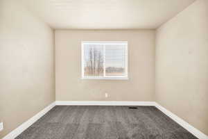 Carpeted spare room with baseboards