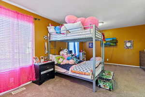 Bedroom featuring carpet and baseboards