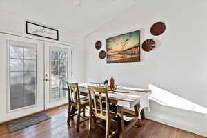 Dining room with hardwood / wood-style floors, french doors, and vaulted ceiling