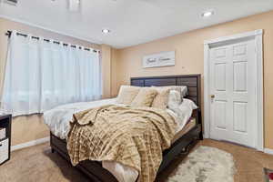 Bedroom featuring light colored carpet, a ceiling fan, and recessed lighting
