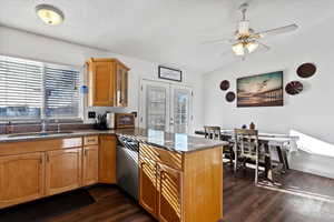 Kitchen featuring french doors, a peninsula, dark stone counters, dark wood finished floors, and lofted ceiling