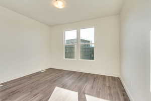 Unfurnished room with light wood finished floors and baseboards