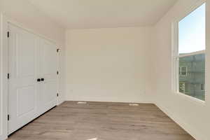 Unfurnished bedroom featuring a closet and light wood-style flooring