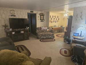 Living room featuring wallpapered walls and carpet.