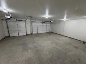 Garage with a garage door opener and baseboards