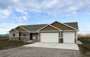 Craftsman inspired home with stone siding, driveway, and a garage