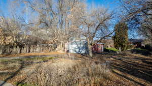View of yard with an outdoor structure and driveway