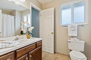 Full bath featuring vanity, a shower with curtain, and light tile patterned floors