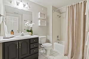 Full bath featuring shower / bath combo with shower curtain, vanity, and light tile patterned flooring