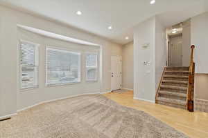 Foyer entrance with stairway, healthy amount of natural light, recessed lighting, and light wood finished floors