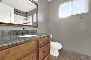 Hallway full bathroom with stone countertop.
