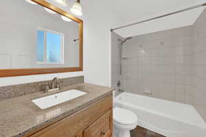 Full en-suite bathroom with stone countertop.
