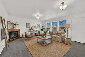 Virtually staged living room off of the dining room level, walk-out to backyard, fireplace (uncertain its function), natural light, fresh paint and new carpet.