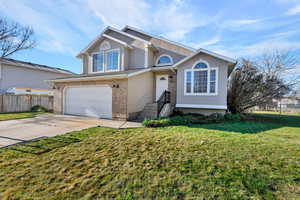 View of front of house featuring driveway, an attached garage, stucco siding, and brick siding