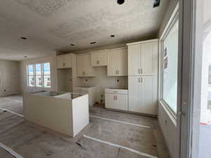 Kitchen featuring a kitchen island and white cabinets