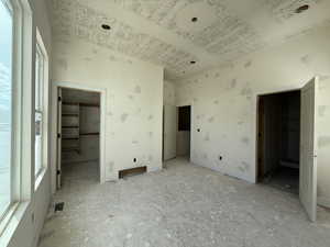 Unfurnished bedroom with a spacious closet and a high ceiling