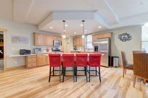 Open plan kitchen area, stainless steel appliances, kitchen island with breakfast bar