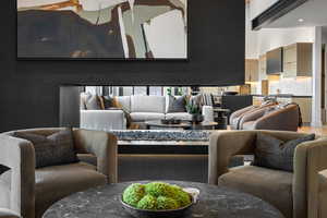 Living room featuring wood finished floors, recessed lighting, and a high ceiling