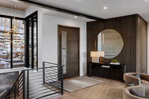 Interior space featuring hardwood / wood-style flooring, recessed lighting, wood walls, an accent wall, and beamed ceiling
