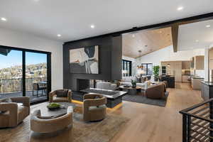 Living room with light wood finished floors, healthy amount of natural light, recessed lighting, and lofted ceiling