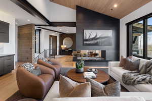 Living room with recessed lighting, light wood-style flooring, a multi sided fireplace, wooden ceiling, and an accent wall