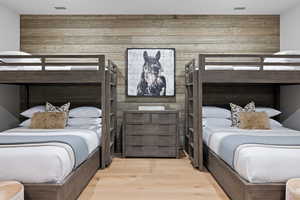 Bedroom with wood walls and wood finished floors