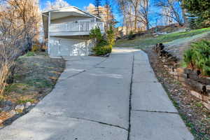 View of property exterior featuring concrete driveway and a garage
