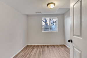 Spare room featuring light wood-style floors and baseboards