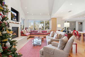 Living area featuring a glass covered fireplace, wood finished floors, and recessed lighting
