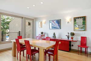 Dining area with light wood-style floors and recessed lighting