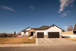Modern farmhouse with board and batten siding, concrete driveway, a garage, and covered porch