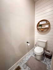 Bathroom with wooden walls and baseboards