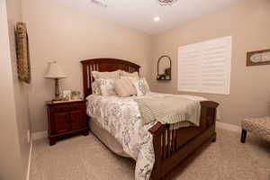 Bedroom with light carpet and recessed lighting