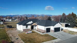 View of front of house featuring board and batten siding, a trampoline, concrete driveway, brick siding, and a garage