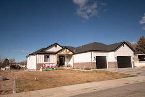 Modern inspired farmhouse with board and batten siding, a front yard, and concrete driveway