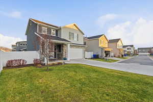 Traditional-style house with concrete driveway, an attached garage, a residential view, and covered porch