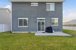 Back of property featuring a fenced backyard, a patio area, and stucco siding