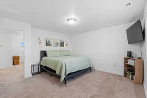 Bedroom featuring light colored carpet and baseboards