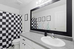 Bathroom featuring a shower with curtain and vanity
