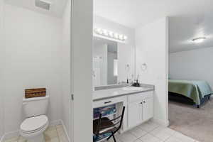 Full bath with vanity, light tile patterned flooring, ensuite bathroom, and light colored carpet