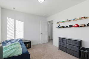 Bedroom featuring light carpet and baseboards