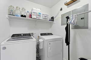 Laundry room featuring electric panel and washer and clothes dryer