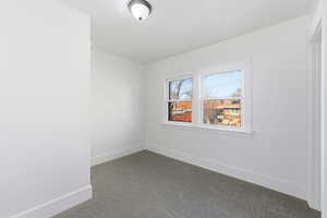 Carpeted spare room with baseboards
