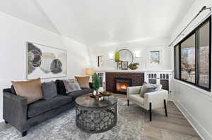 Living area featuring light wood-style floors and a brick fireplace