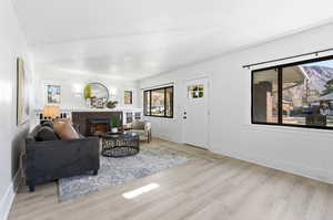 Living area with a brick fireplace and light wood-type flooring