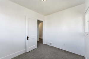 Spare room featuring arched walkways and carpet floors