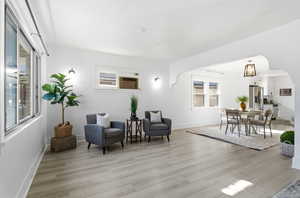 Sitting room featuring arched walkways and light wood finished floors